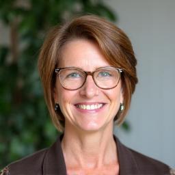 Professional headshot of Eleanor Vance, a warm and confident woman in her 50s.